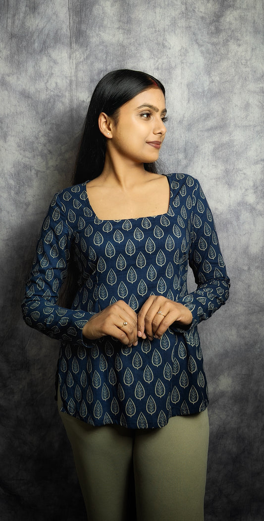 Woman wearing a blue patterned top against a gray background