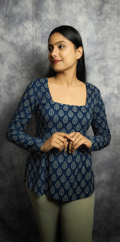 Woman wearing a blue patterned top against a gray background