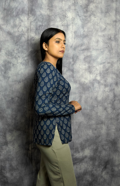 Woman wearing a blue patterned top against a gray textured background